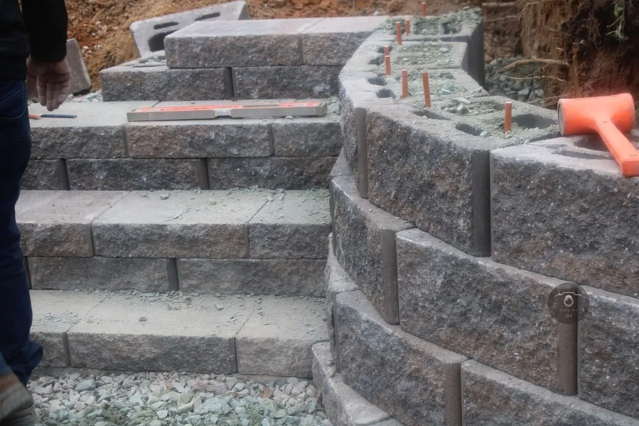 Curved stone retaining wall and steps under construction