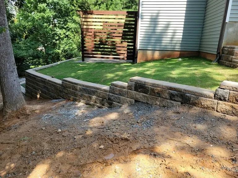 Finished stacked-stone retaining wall and manicured lawn